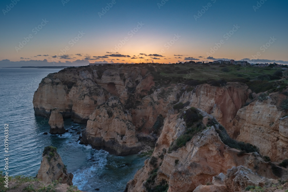 Sunset over the cliffs and beaches by Atlantic Ocean, Lagos, Algarve, Portugal