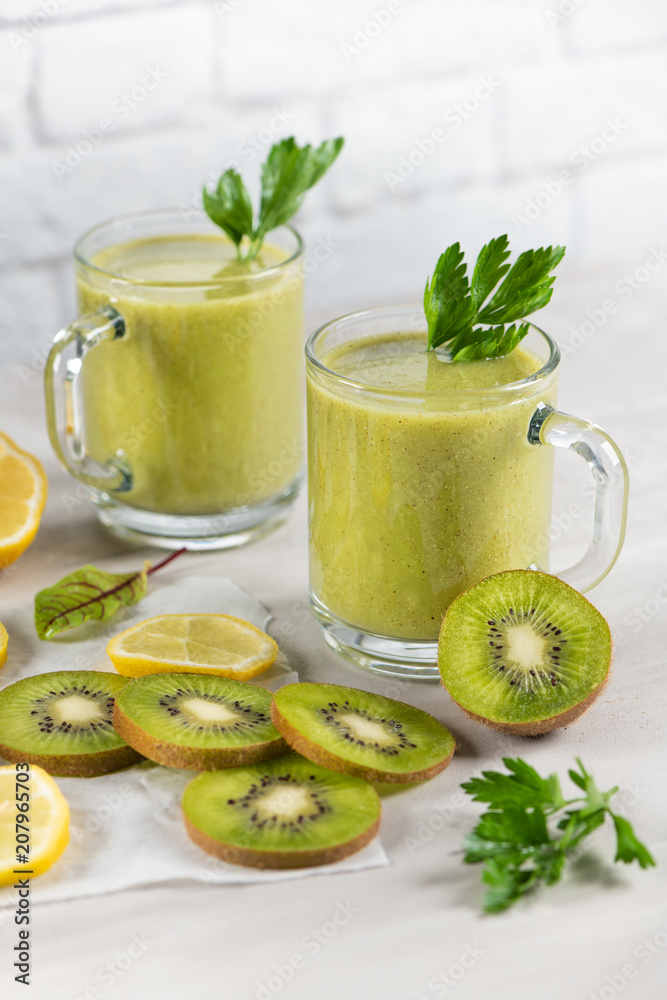 A freshly prepared smoothie of kiwi, lemon, orange and parsley on a cement table. Diet vegetarian food. Raw foods A freshly prepared smoothie of kiwi, lemon, orange and parsley on a cement table. Diet vegetarian food. Raw foods