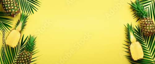 Fototapeta Wzór z jaskrawymi ananasami na żółtym tle. Widok z góry. Skopiuj miejsce. Minimalny styl. Pop-art design, koncepcja kreatywnych lato. Transparent