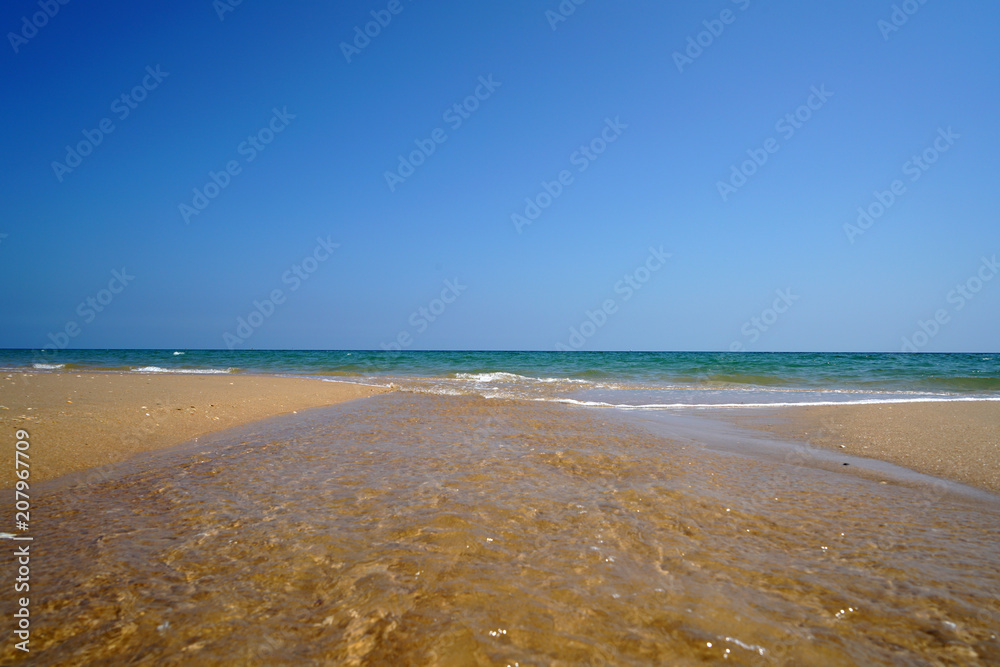 Obraz premium Lonely Atlantic beach in spring in Portugal with light swell 