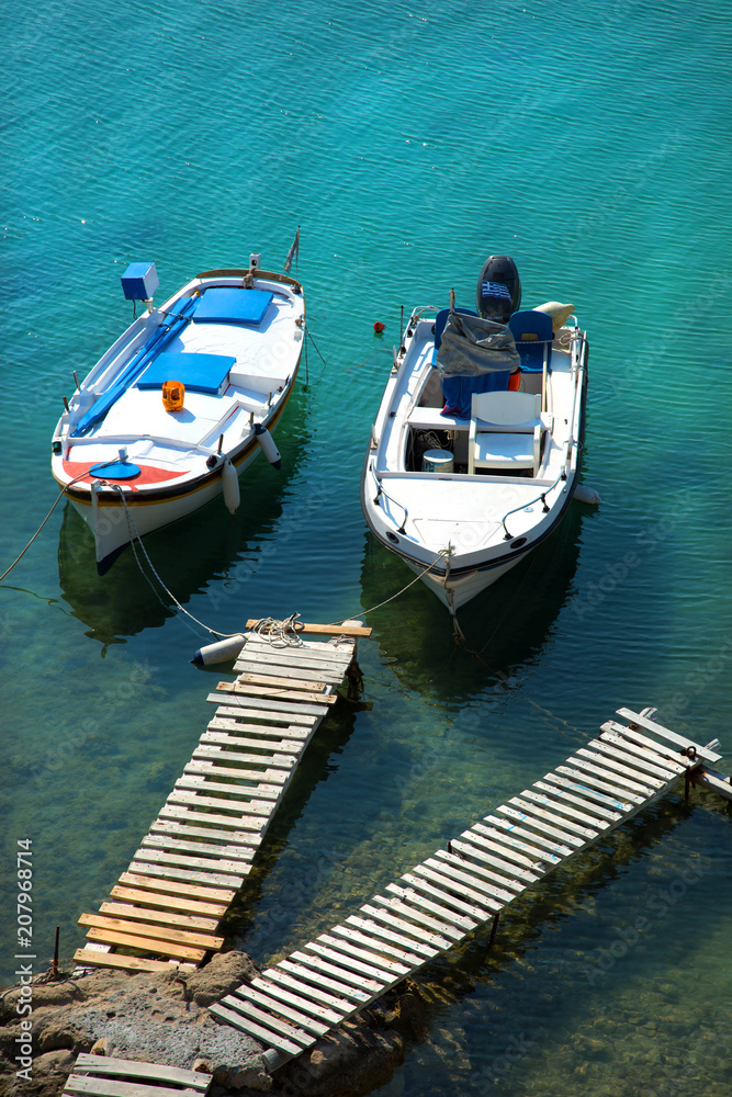 Fishing boats floating in turquoise water in Greece