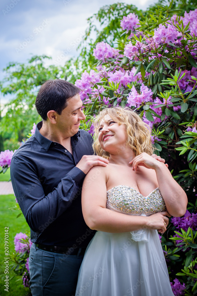 Bridal wedding plus size couple woman and man sitting with heads together on park. Bridal wedding plus size couple woman and man sitting with heads together on park.