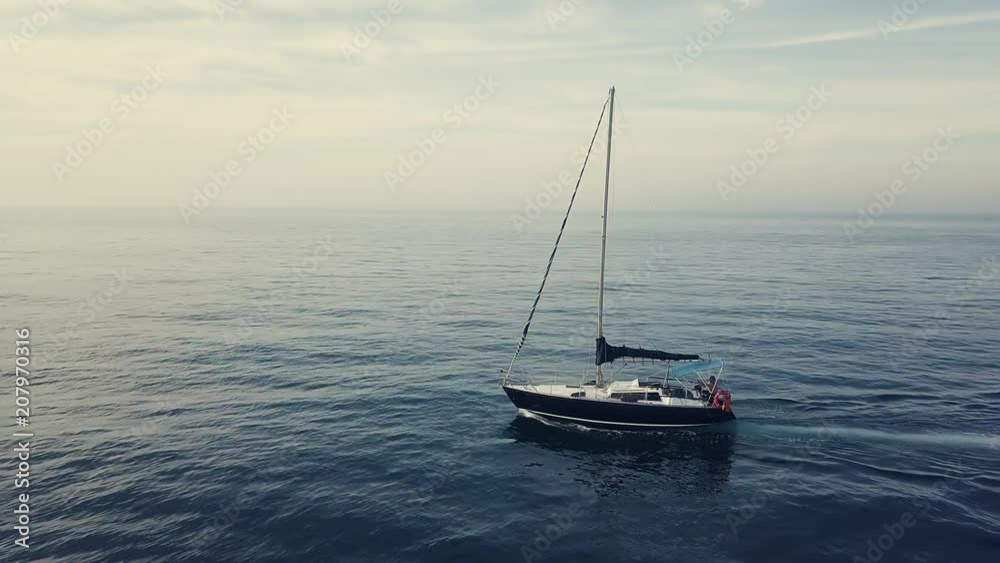 4k lateral aerial of sailing boat in sunset cloudscape, boat leaves the scene 4k lateral aerial of sailing boat in sunset cloudscape, boat leaves the scene