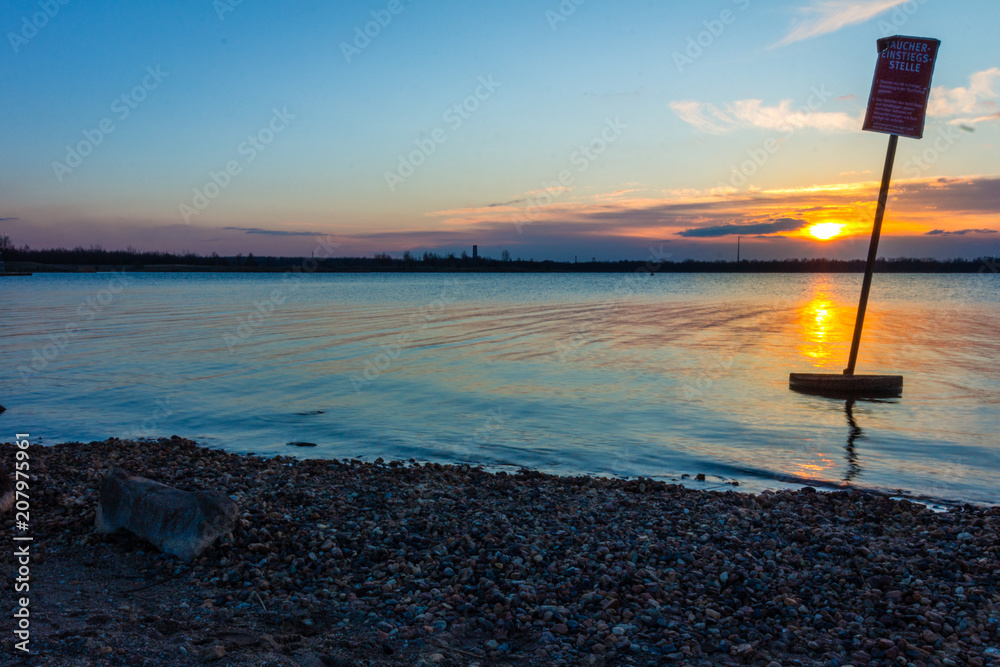 Sonnenuntergang am See mit blauem Himmel