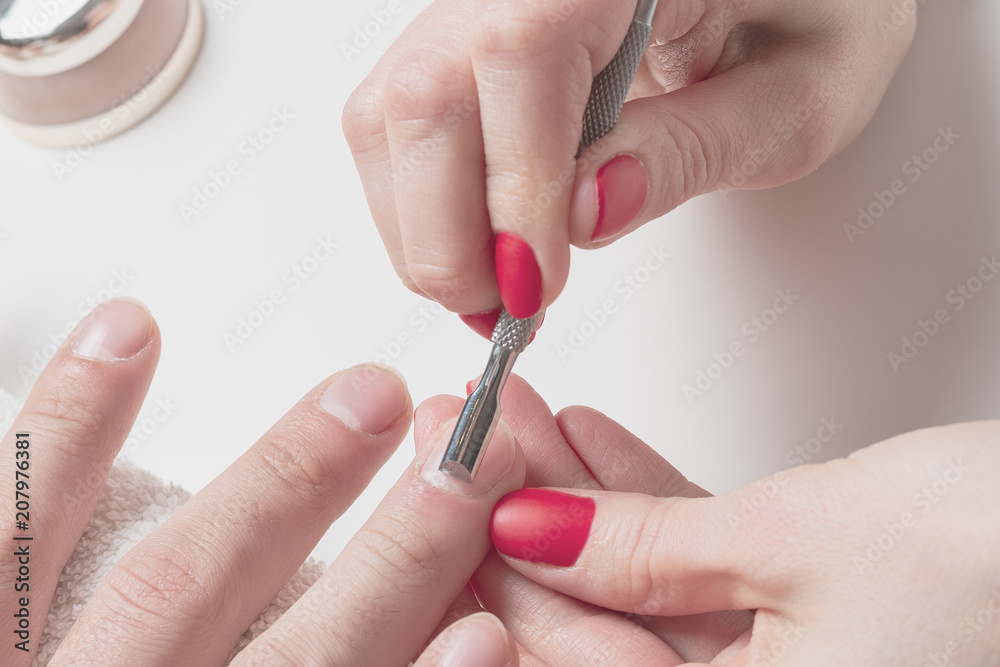 Men's manicure. hands of the beautician treated cuticle of male hands using pusher, scraper