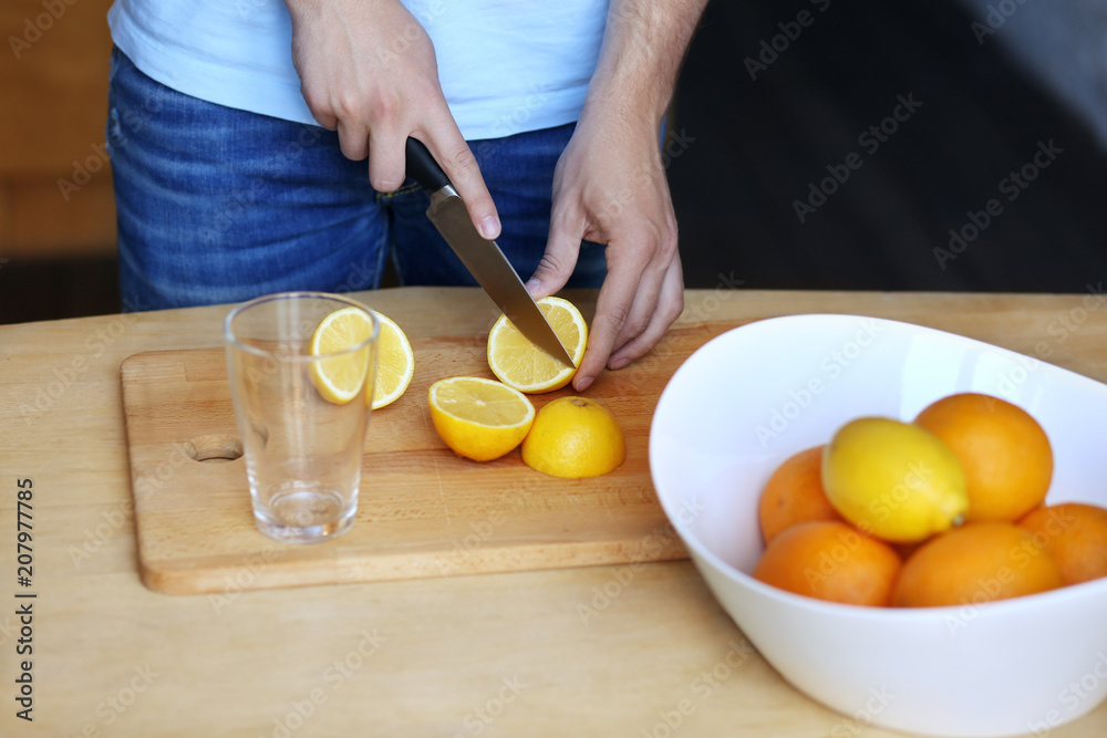 Preparation of lemonade,hand with a knife cutting lemon on wooden board. Preparation of lemonade,hand with a knife cutting lemon on wooden board.