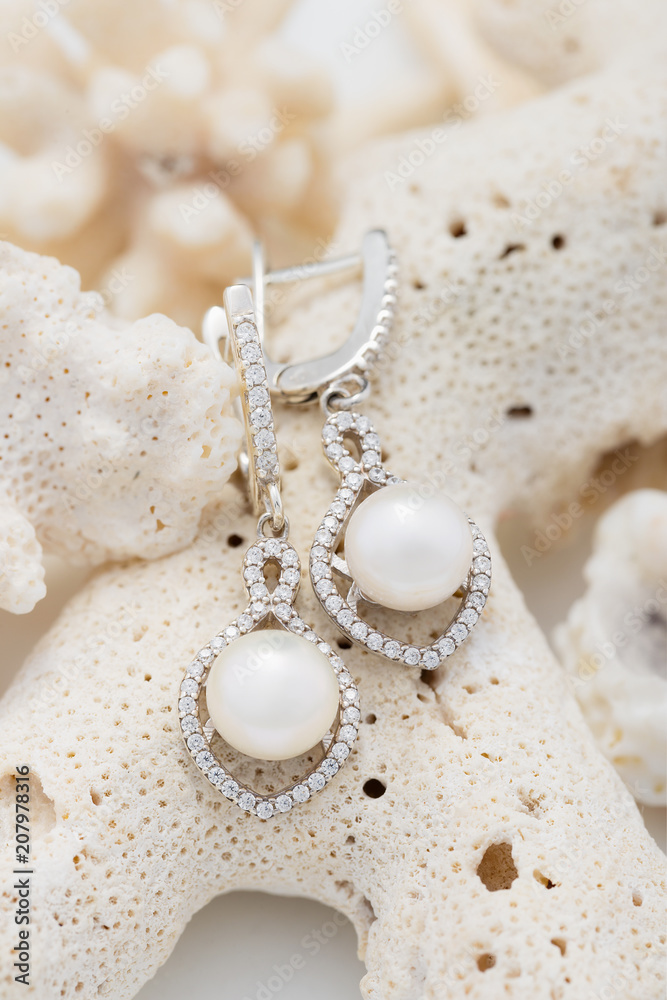 Silver earring with pearl and diamonds on coral Silver earring with pearl and diamonds on coral