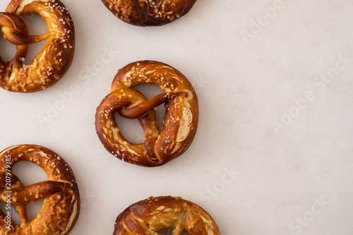 Freshly baked homemade soft pretzel with salt on white background. Top view.