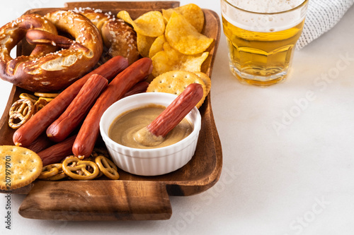 Snack to beer, Bavarian sausages, chips, brezels, crackers and mustard. Oktoberfest food, appetizing beer snacks set for big company. photo