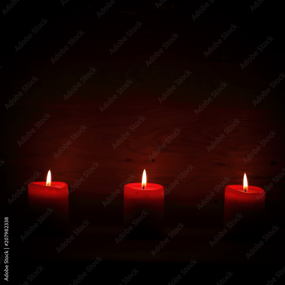 three candles on an abstract festive background