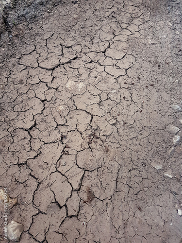 Cracked ground, path, dry soil. Ecology concept. Cracked earth texture and background. Dry field, water, land, sand. Above view of land during drought. Abstract surface, pattern, material, wallpaper.