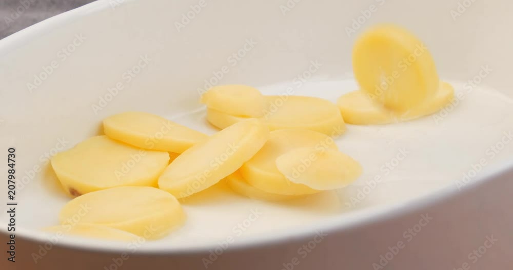 Fresh potato slices falling in oven dish. Preparing to cook a meal wiht fresh ingredients. Fresh potato slices falling in oven dish. Preparing to cook a meal wiht fresh ingredients.