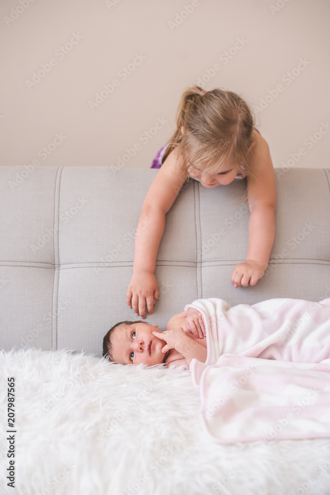 Older sibling playing with her newborn sister Older sibling playing with her newborn sister