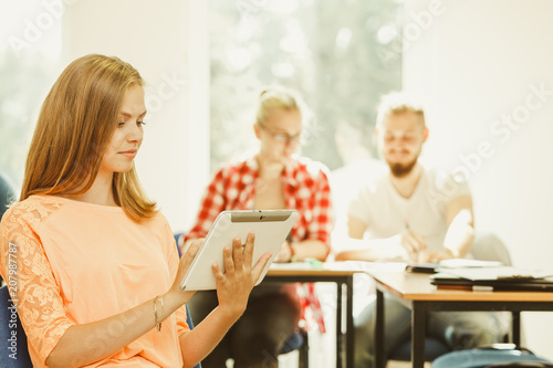 Student girl with tablet in front of her classmates