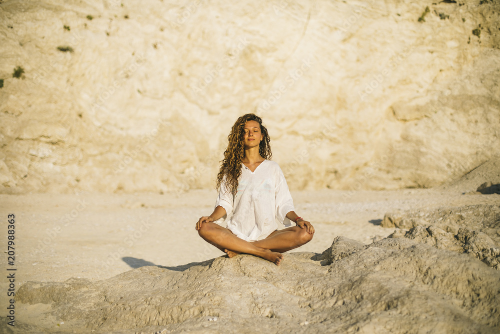 © Aleksandar Novoselski/Stocksy - Young woman practicing yoga at the beach, by sunrise © Aleksandar Novoselski/Stocksy - Young woman practicing yoga at the beach, by sunrise