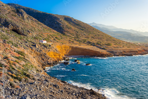 Scenic landscape with the church Agios Konstantinos on a hill and aegean sea, Milatos, Crete, Greece. photo