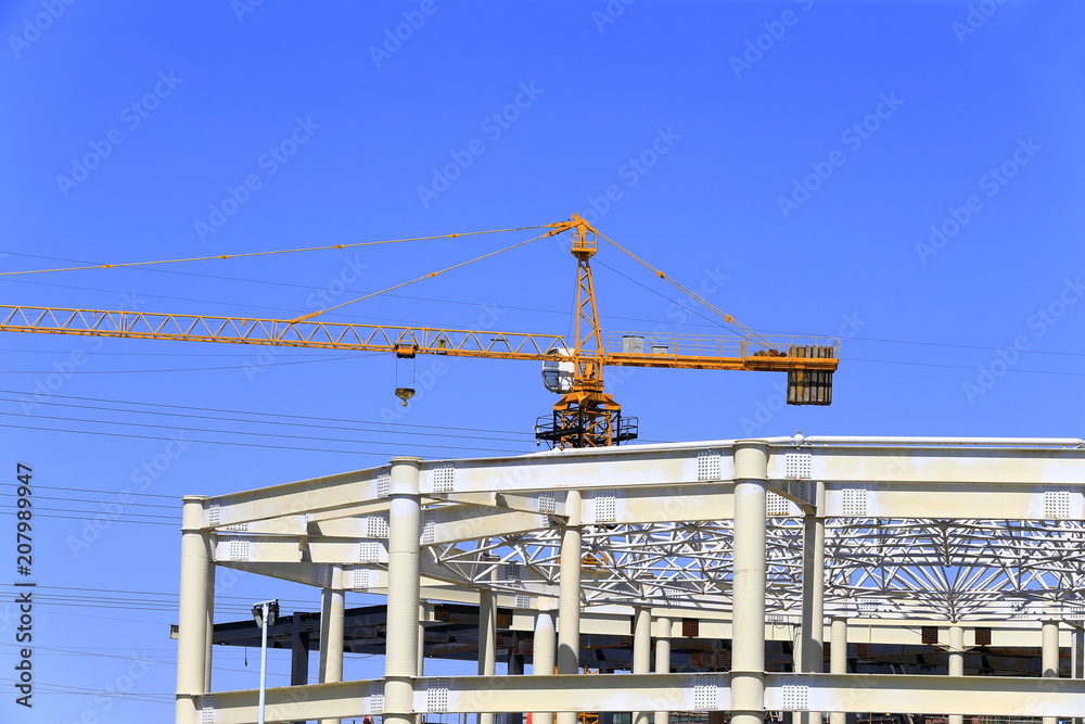 The crane is working at the construction site The crane is working at the construction site