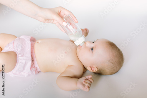 Mother is feeding newborn baby. A woman feeds a newborn with modified milk from a bottle