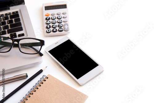 White office desk table, workspace office with laptop, smartphone black screen, pen, calculator, glasses, Top view with copy space