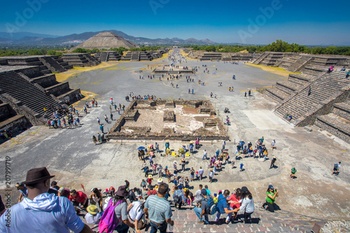 View of the Sun Pyramid and the Alley of Death - City of Teotihuacan Mexico - Ancient Maya Pyramids with people climbing the steps of Moon Pyramid.