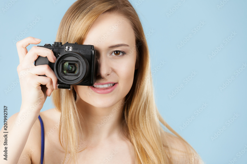 Blonde woman with camera on blue Blonde woman with camera on blue