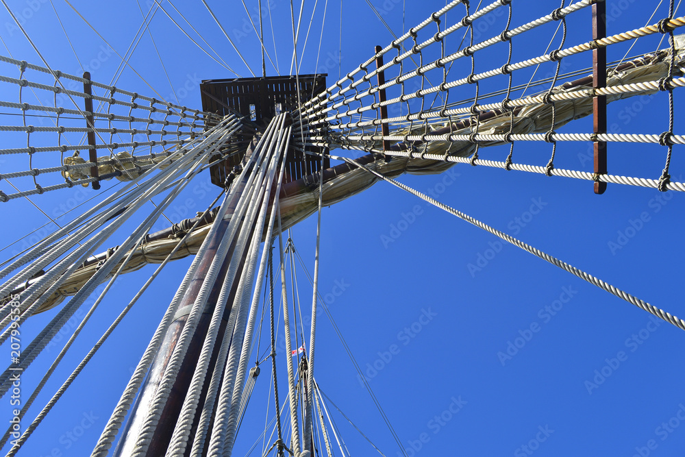 Obraz premium Vintage tall ship mast and rigging under blue sky