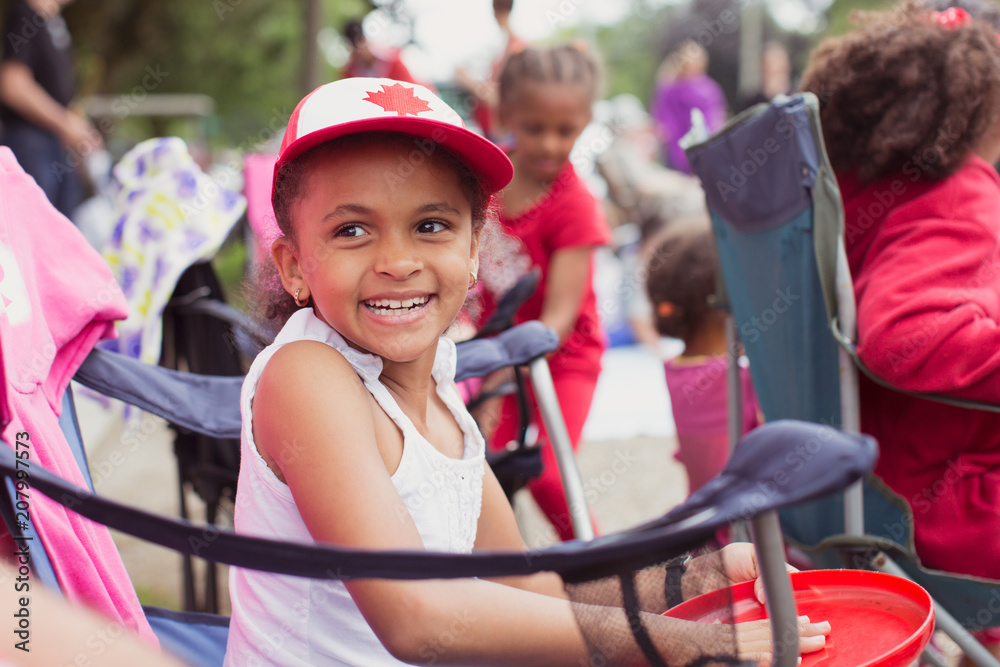 Portrait of a beautiful young girl smiling happily as she waits for the Canada day parade Portrait of a beautiful young girl smiling happily as she waits for the Canada day parade