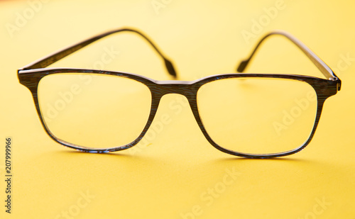 graduated glasses on yellow background