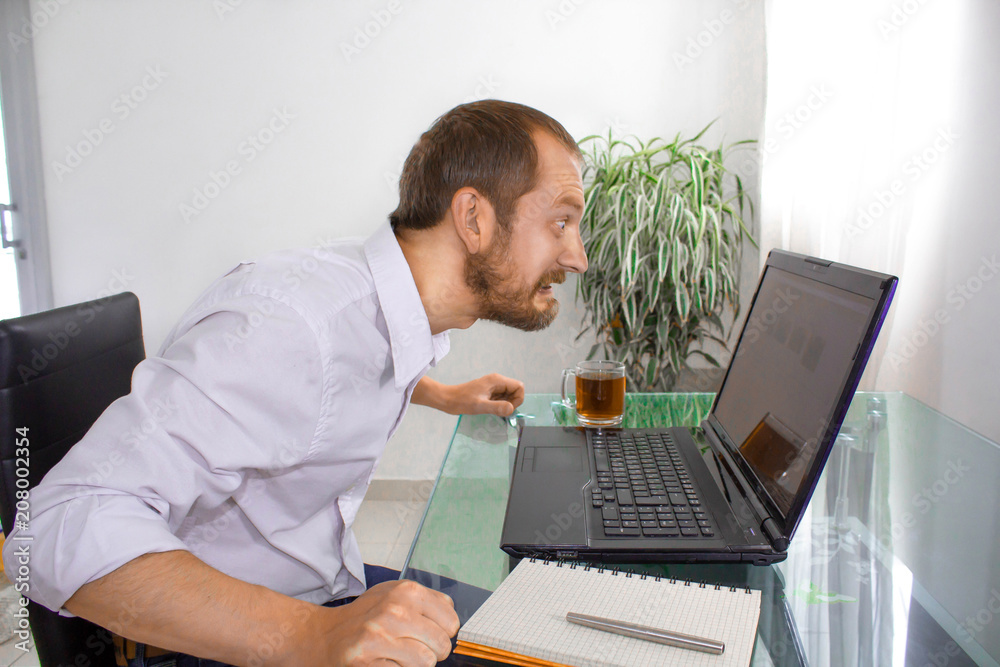 The man at the computer is angry The man at the computer is angry