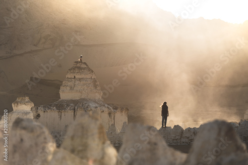 Man Stands In A Misty Mountain Valley Near A Religious  Tibetan Stupa photo