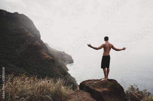 A man standing on the rock observing the coastline view