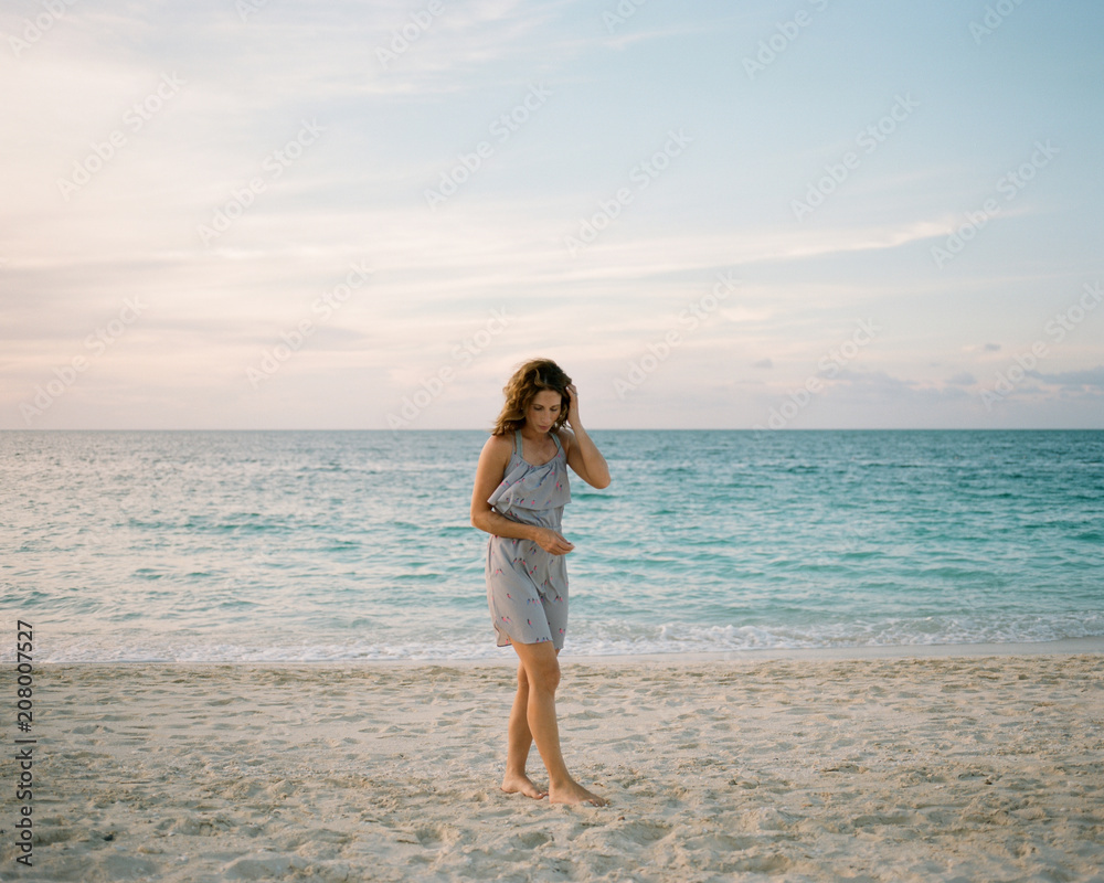Beautiful woman looking for shells on the beach Beautiful woman looking for shells on the beach