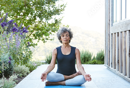 African American Senior woman doing yoga at home photo