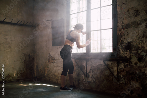 Young strong brunette woman resting after boxing workout.