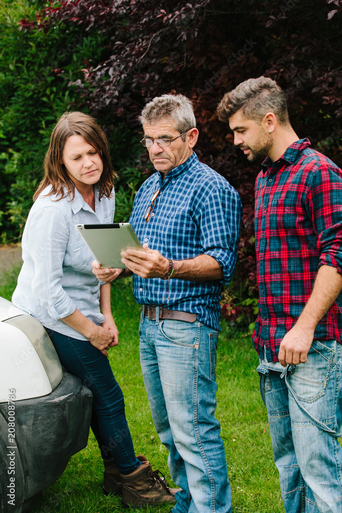 Garden maintenance team discuss work and use a tablet