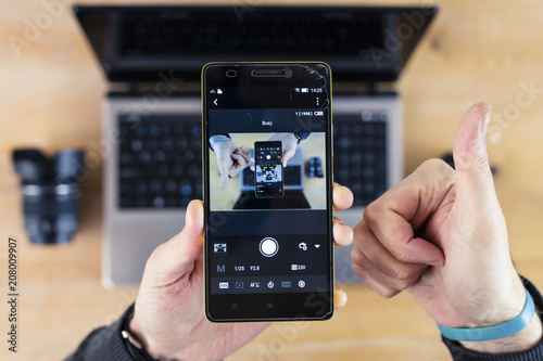 Smartphone in Hand, Thumbs-Up Sign, and Laptop Droste Effect