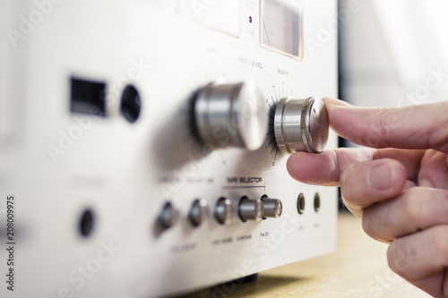Hand Turning a Knob on a Vintage Home Stereo Equipment