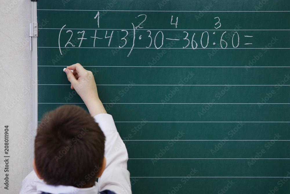 Pupils writes chalk on blackboard Pupils writes chalk on blackboard