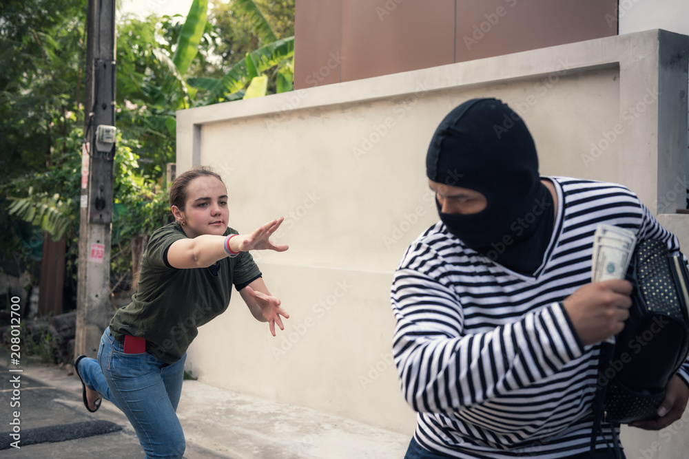 Snatch thief stealing money and handbag from tourist woman, Robber, Thief  concept Stock Photo