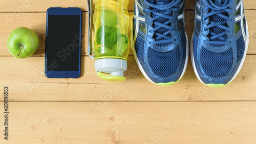 A freshly prepared drink made of lemon and mint and ginger on the background of sneakers wooden floor. The view from the top. Flat lay.