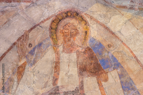 Christ pantocrator rises his right hand, an ancient romanesque mural photo