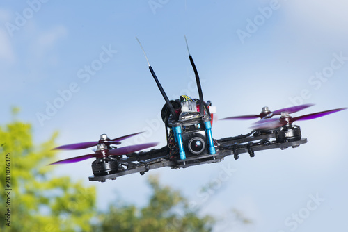 radio-controlled quadcopter with camera for video and photo shoot speedy orange-red racing on white background isolated