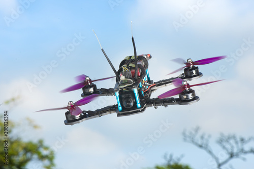 Fototapeta Naklejka Na Ścianę i Meble -  radio-controlled quadcopter with camera for video and photo shoot speedy orange-red racing on white background isolated