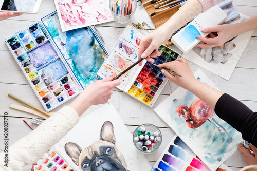 creative leisure. painting hobby. artful personalities working together. watercolors and drawings scattered on the table
