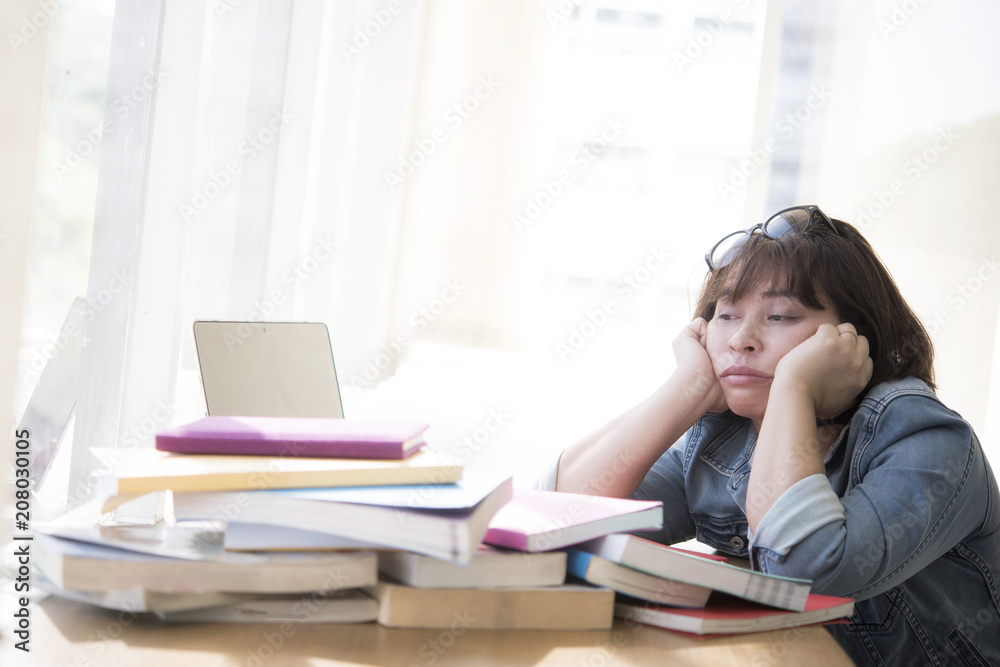 Bored young female student sitting in a campus open space library , Bored young female student sitting in a campus open space library ,
