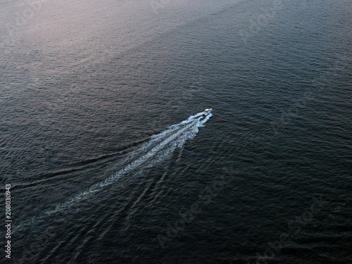A motorboat cruising down the Hudson river from above.