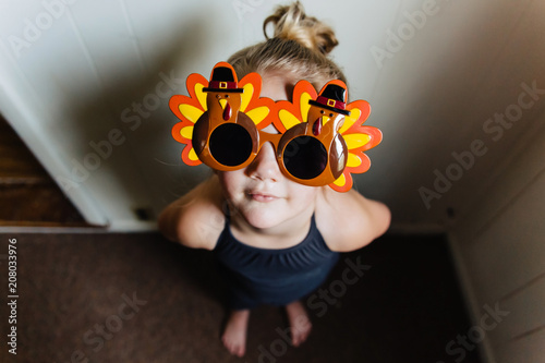 Cute toddler girl wearing Thanksgiving turkey sunglasses. photo