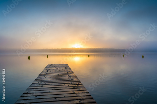 Sonnenaufgang am See mit Steg im Nebel
