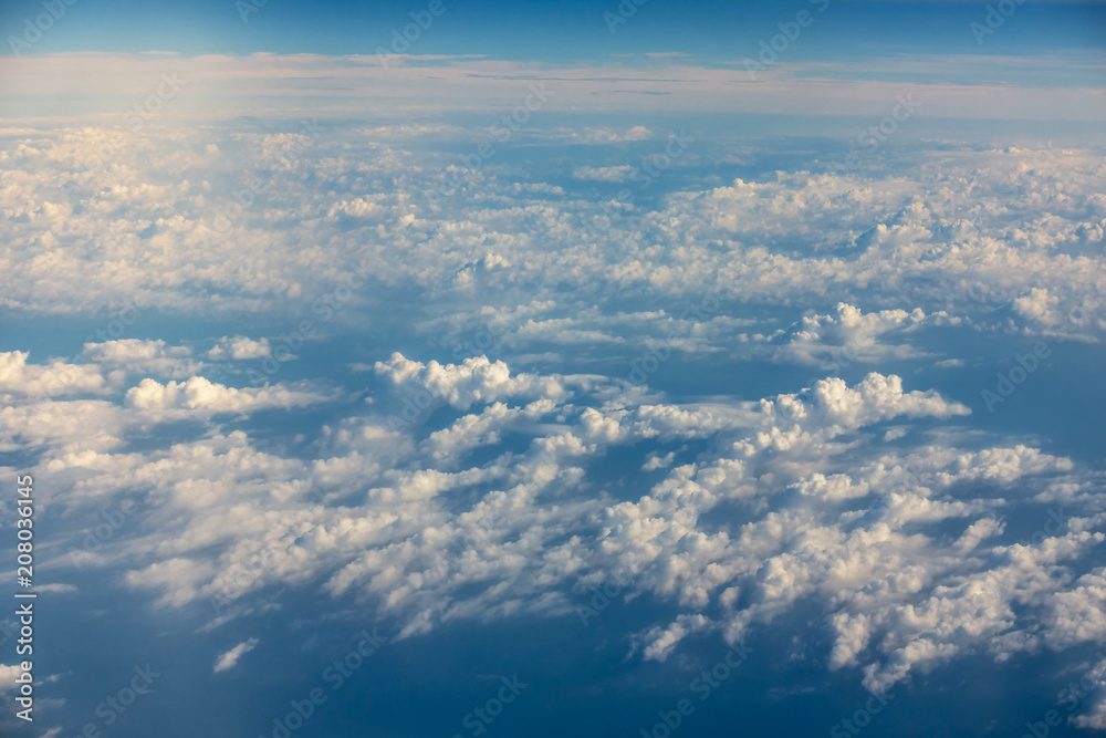 Wing of an airplane flying above the clouds. Wing of the plane on blue sky background., Traveling concept..