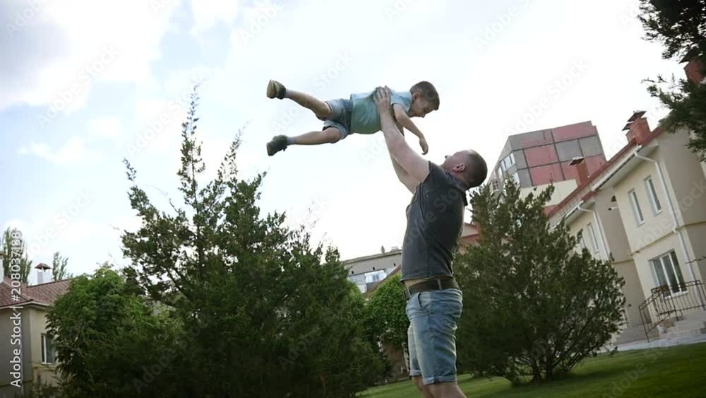 Family have fun playing on backyard, father enjoy throw up in air his son kid Family have fun playing on backyard, father enjoy throw up in air his son kid